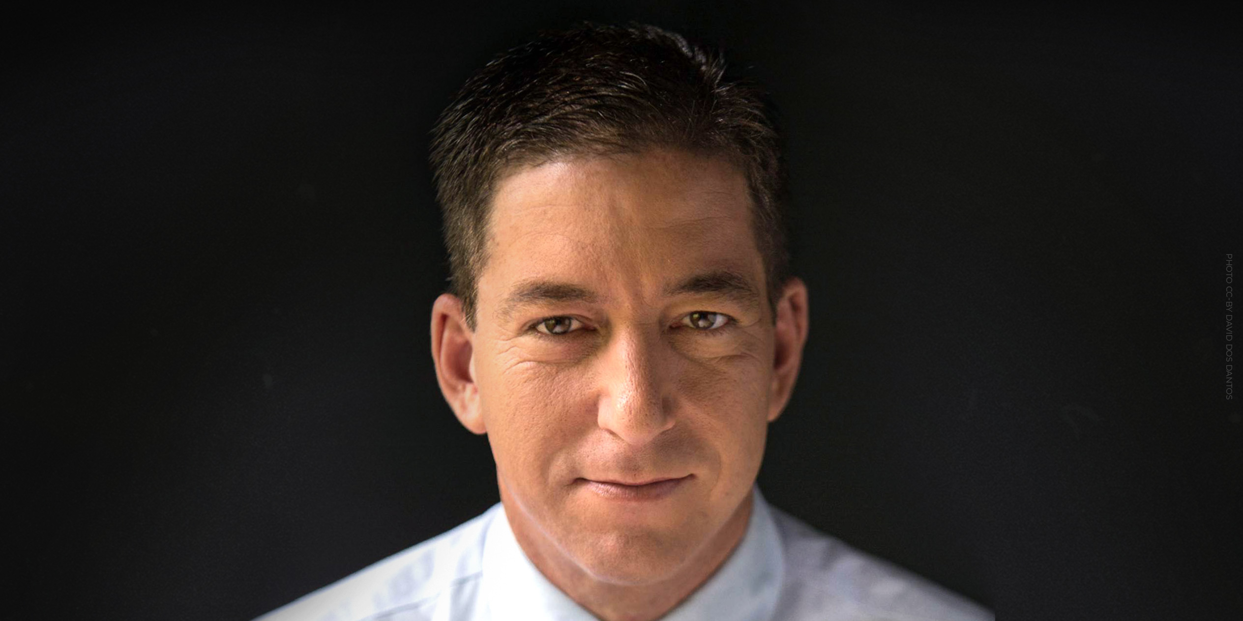 Portrait of Glenn Greenwald against a dark background. Photo by David dos Dantos CC-BY