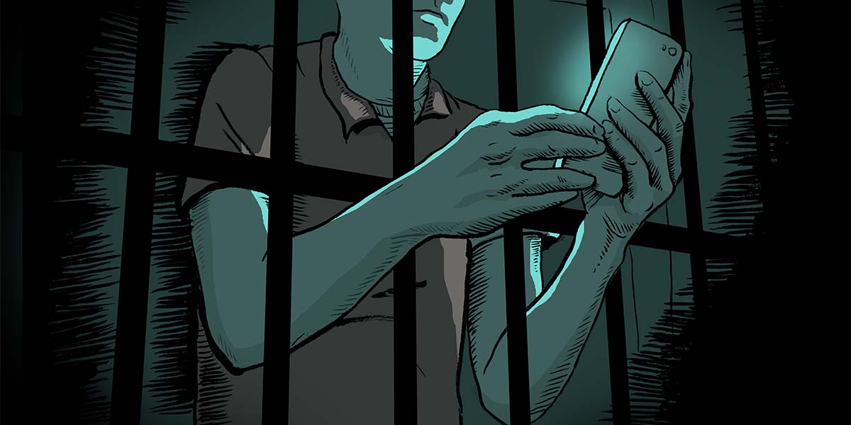 an imprisoned person uses a mobile phone through the bars