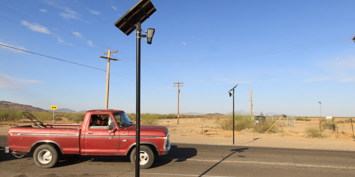 Flock Safety cameras A red truck carrying a lawnmower drives past two Flock Safety automated license plate readers.