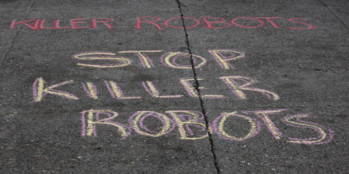 chalk on the sidewalk reading "STOP KILLER ROBOTS" 